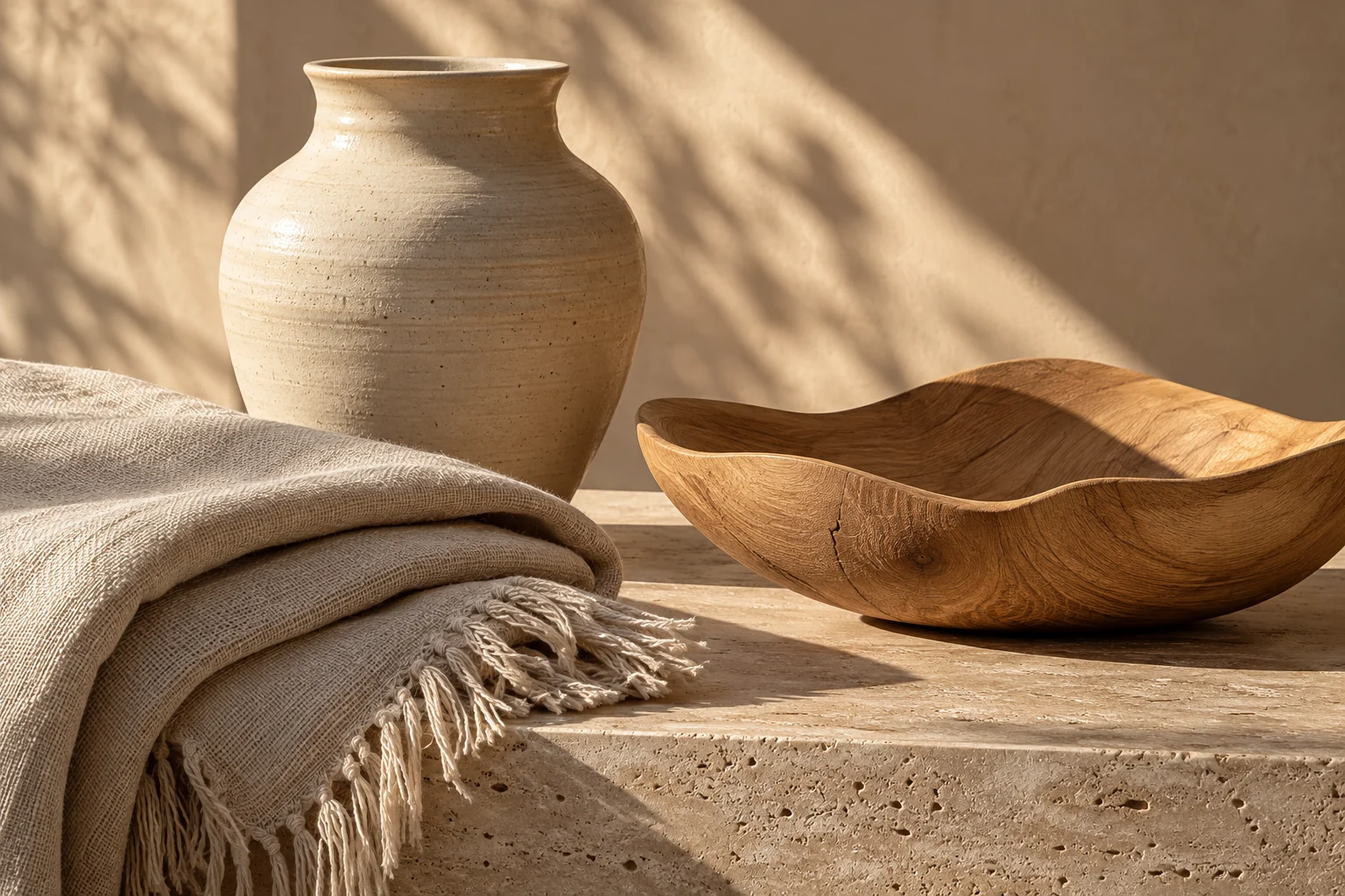A cream ceramic vessel, natural linen and a sculptural wooden bowl